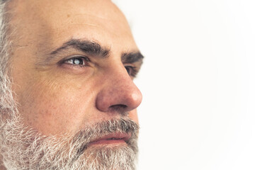 Obraz premium Worried man in his 40s with gray hair and beard looking off the camera - extreme close up. High quality photo