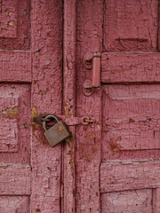Closed lock on old wooden door with peeled off paint