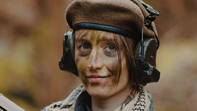 armed female soldier portrait caucasian woman in her 20s looking to the camera and smiling - army career concept. High quality 4k footage