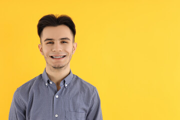 Attractive guy in shirt on yellow background