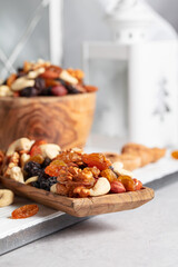 Mix of nuts and raisins on a white wooden table.