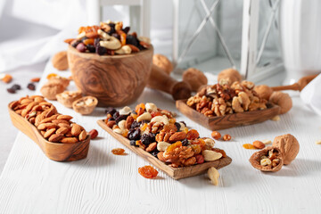 Mix of nuts and raisins on a white wooden table.