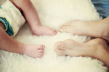 Obraz na płótnie Canvas Feet of a newborn baby . Happy Family ,Mum
