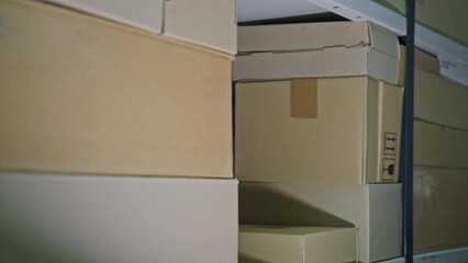 A man in gloves steals box in a warehouse. Problems with theft and security in the office
