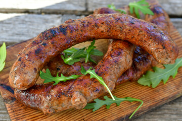 Grilled  pork  juicy sausages on wooden board outdoors. Grilling food, bbq, barbecue, picnic