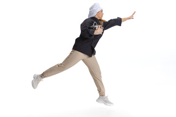 Studio shot of young woman, lady-cook, chef in black uniform running isolated on white background. Cuisine, profession, business, food, taste, restaurant concept.