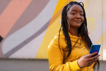 UK, South Yorkshire, Portrait of woman with braided hair holding smart phone © Cultura Creative