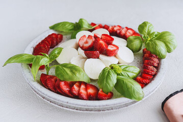 Summer Caprese salad with strawberries. Strawberry salad with basil and mozzarella. Healthy eating concept. Italian cuisine - 486088099