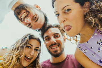 Best friends take a selfie from below making funny faces - college students on vacation have fun together.