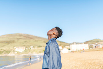 african american man breathing fresh air at the beach on a sunny day