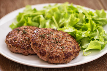 Homemade Hamburgers with Green Salad on a Plate.