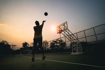 Basketball player silhouette at sunset. basketball player shoots a shot. Sport basketball concept.