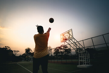 Basketball player silhouette at sunset. basketball player shoots a shot. Sport basketball concept.