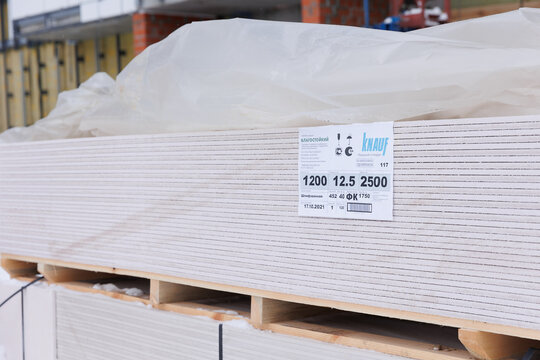 PERM, RUSSIA OCTOBER 10, 2021: Sheets of moisture-resistant thick gypsum board on a pallet ready to use at the construction site. Knauf brand German technology