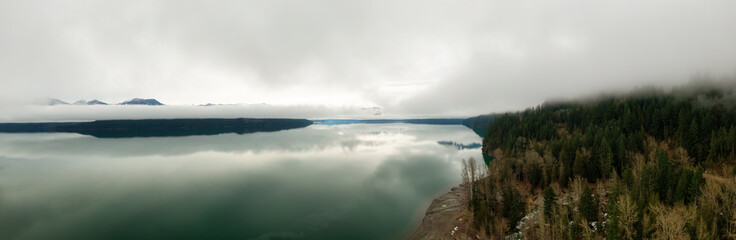Obraz premium Aerial Panoramic View of Canadian Mountain Landscape covered in fog over Harrison Lake. Winter Season. British Columbia, Canada. Nature Background Panorama