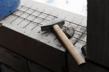 steel hammer lies on the masonry at the construction site. steel mesh for reinforcing the masonry of concrete blocks of gas blocks.