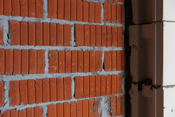 Brickwork of red lightweight clay bricks. Construction of the wall with metal mesh binding in...