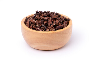 Cocoa nibs in wooden bowl isolated on white background with clipping path.