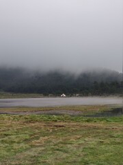 Naklejka na ściany i meble paisaje con neblina frente a un lago una tarde de lluvias 