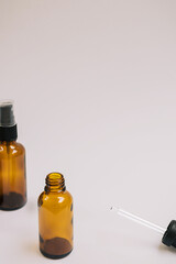 Serum or essential oil in brown glass bottle with pipette and on white grey background. Minimal DIY natural organic cosmetic concept. Facial skin care. Zero waste product. Mock up with copy space.
