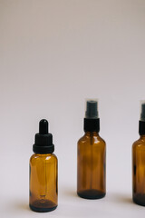 Serum or essential oil in brown glass bottle with pipette and on white grey background. Minimal DIY natural organic cosmetic concept. Facial skin care. Zero waste product. Mock up with copy space.