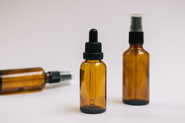 Serum or essential oil in brown glass bottle with pipette and on white grey background. Minimal DIY natural organic cosmetic concept. Facial skin care. Zero waste product. Mock up with copy space.