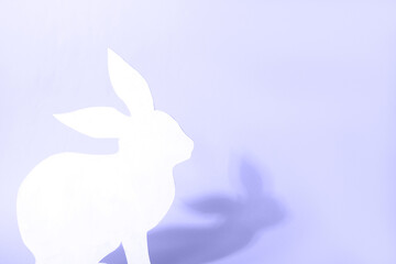 White Easter bunny on violet background. Easter holiday concept with cute handmade bunny