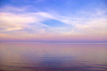 Obraz premium Sky background on sunset, colorful clouds. Nature abstract composition with reflections on sea water. Nature environment.