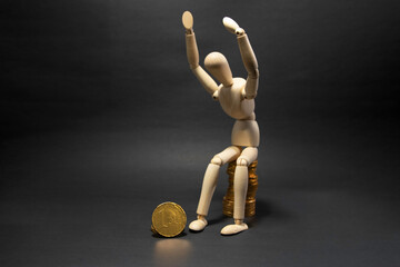Wooden figure mannequin sitting on a pile of coins being happy on a black background. Business Concept