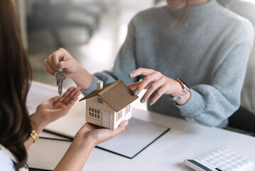 Fototapeta na wymiar Home and real estate trading business. Real estate agent giving keys to house woman owner.