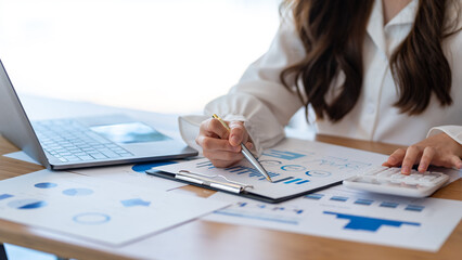 Close up of a businesswoman hand using a calculator to calculate business principles. Accounting...