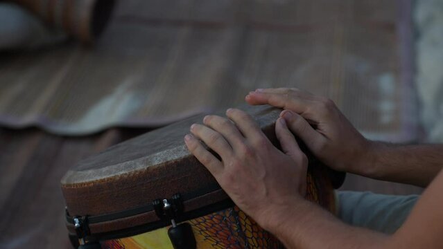 Male hands playing bongo drums, close up. Hand tapping a Bongo drum in close up. Drums hands, movement, rhythm