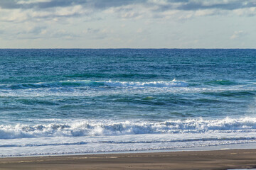 Waves and black sand highlight a visit to the beach. Taranaki, Beach, Taranaki, New Zealand..