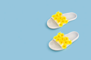 Creative spring concept with rubber slippers with yellow flowers