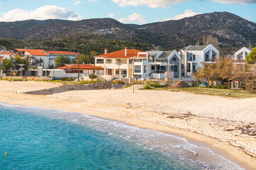 Houses and villas in a resort town Kalamitsi in Sithonia, Halkidiki, Greece on mountain slope at the Mediterranean Sea. Real estate and urban development concept
