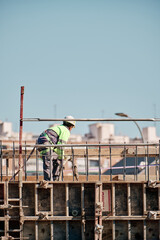 Construction worker working at heights holding a concrete hose
