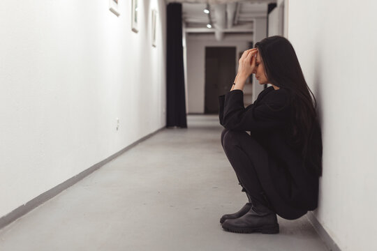 Stressed overworked young business woman sitting on floor. Fired and depressed in office.
