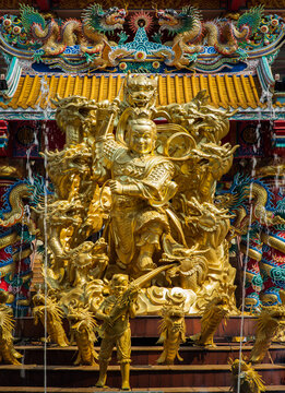Chonburi, Thailand - 05 Feb 2022 : Nezha guardian deity gold statue and Dragons at Wihan Thep Sathit Phra Kitthi Chalerm Shrine (Nacha Sa Thai Chue Shrine or Naja Shrine). Selective focus.