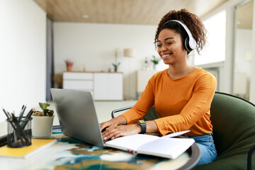 Portrait of smiling black woman using laptop at home