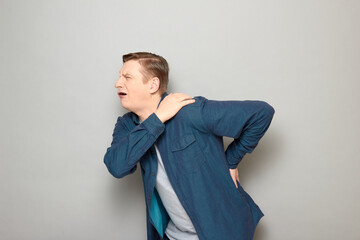 Shot of unhappy mature man suffering from pain in shoulder and back