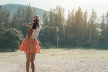 young female golf player hit sweeping and keep golf course doing golf swing,she does exercise for relax time