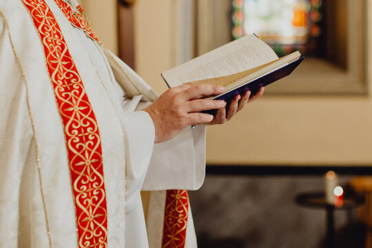 les mains du pr&ecirc;tre lisant la Bible