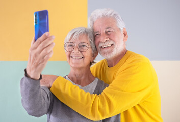 70 years old handsome caucasian senior couple standing over isolated colorful background using...