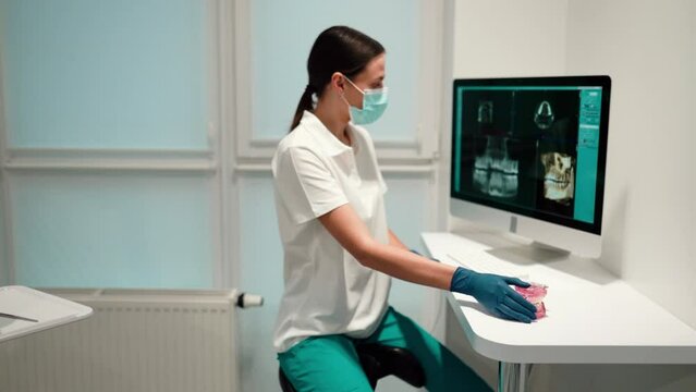 Doctor or dentist presenting with tooth x-ray film recommend patient in the treatment of dental and dentistry, working at workplace.