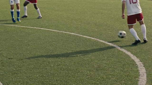 Close up of a soccer player receiving a pass and shooting the ball towards the goal on a soccer field. Soccer players are wearing unbranded sports clothes. 4k slow motion video.