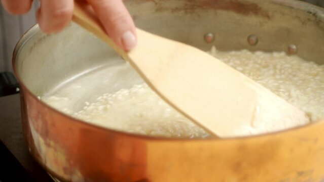 Unrecognizable cook preparing risotto in pan