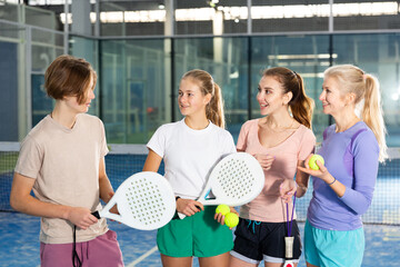 Four confident tennis players of different ages, discussing topical issues of the upcoming game on...