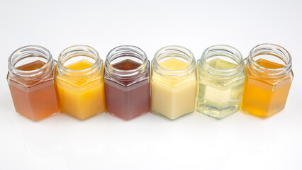 Hexagonal jars with different types and colors of fresh flower honey. vitamin food for health and life