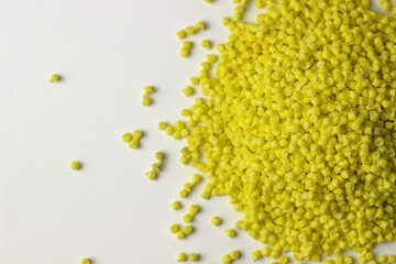 yellow granules of polypropylene, polyamide. White background. Plastic and polymer industry. Microplastic products.	