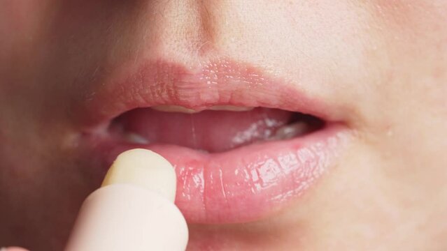 Anonymous female applying balm in morning